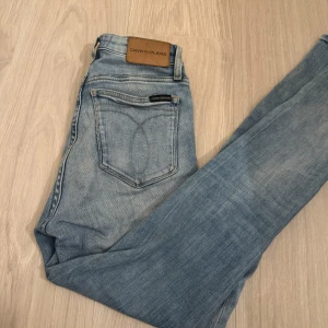 Ljusblå jeans från Calvin Klein - Snygga ljusblå jeans från Calvin Klein i en skinny fit. De har hög midja och klassisk femficksdesign med subtila CK-loggor på fickorna. Använda men i bra skick. Mina favoritbyxor så köpt nya då dessa är för små, därav säljer jag. Ord.pris ca 1200kr