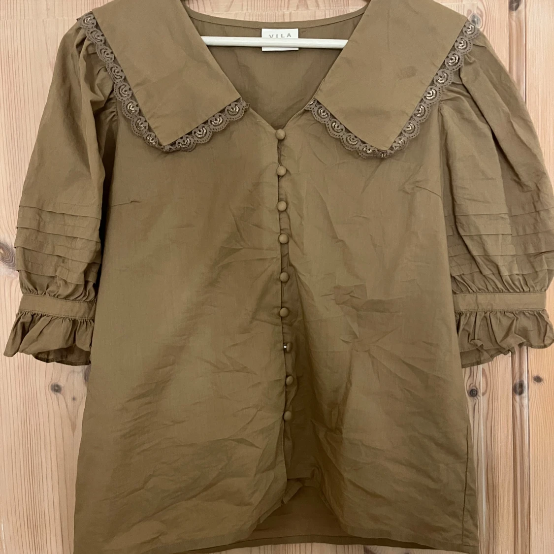 Grönaktig blus med spets och knappar