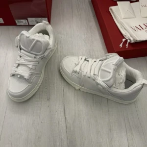  Valentino Garavani ev bytes - Snygga vita sneakers från Valentino Garavani med klassisk snörning och stilren design. Perfekta för en trendig look. Bytes mot andra skor eller nått annat kul 