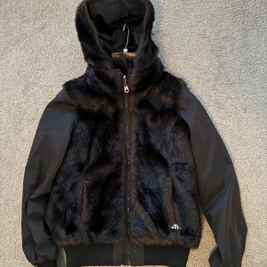 Svart/brun pälsjacka  - Snygg svart/brun pälsjacka som är använd endast ett fåtal gånger. Jacka har en avtagbar huva samt är vändbar. Miss Sixty är varumärket. 