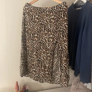 Leopardmönstrad kjol från Amisu - Snygg leopardmönstrad kjol från Amisu i storlek L. Kjolen har en klassisk design med ett djärvt mönster som ger en trendig look. Perfekt för att lägga till lite vild stil i garderoben.