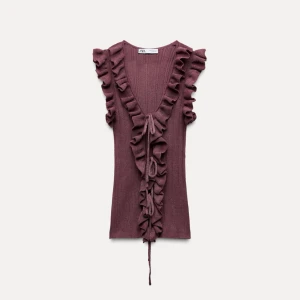 Vinröd topp från Zara - Säljer en vinröd ribbad topp från Zara med volangdetaljer och knytning framtill då jag råka få med två från Zara. | Aldrig använd, prislappen är kvar. Köpte på rea för 199, säljer för 150 💕