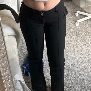 Svarta byxor med bootcut - Snygga svarta byxor lågmidjade. De har fickor på sidorna, två knappar. Fint skick använda 3-5 gånger