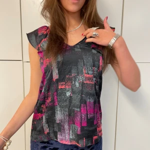 FESTTOPP MÖNSTRAD - Färgglad topp perfekt till fest med volang på axlarna.  Tjejen på bilden är 175 cm lång och toppen är i storlek S. Hör av er vid frågor!!