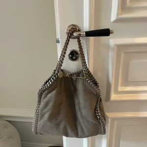 Stella McCartney väska  - Säljer min gråa stella McCartney väska i medium storleken. Väldigt bra skick utom att den rostat på den korta kedjan (se bild 2)