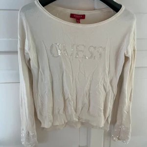 Guds tröj  - Beige/vit stickat tröja från guess där de står guess med paljetter och det är paljetter längst ner på armen 