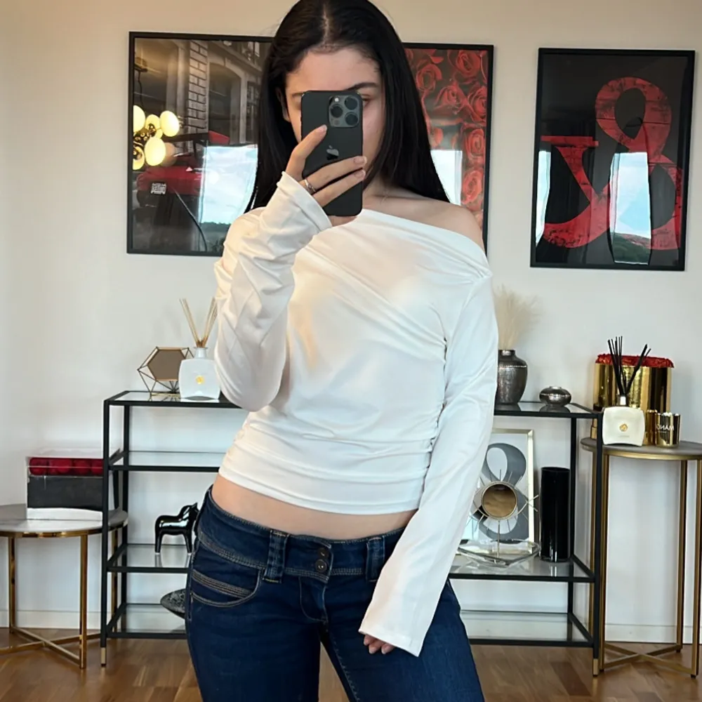 Säljer en superfin vit off-shoulder topp som är perfekt för både vardag och fest. Den är långärmad och har en tight passform som framhäver figuren. Materialet känns mjukt och stretchigt, vilket gör den bekväm att bära hela dagen. Toppen är stilren och kan enkelt matchas med både jeans och kjol.. Toppar.