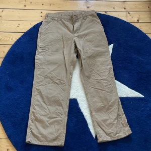 Bruna Carhartt-byxor - Bruna cargobyxor från Carhartt. Byxorna är i gott skick och har använts i ca ett halvår. Ordinarie pris var 899