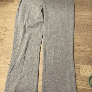 Mjukis byxor Gina låg mindjade  - Utsvängda lågmidjade mjukis från Gina i grå och svart 