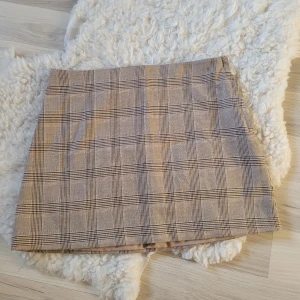 Kjol - Beige kjol från H&m med typ rutigt mönster, i ny skick.