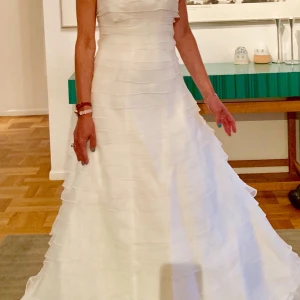 Brudklänning från Garamaj - Brudklänning från Garamaj. Axelbandslös med våder hela vägen. Fint skick. Stl 34