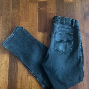  Nudie Jeans svarta mycket bra skick - Snygga svarta jeans från Nudie Jeans storlek w28 L30 mycket bra skick andvänd några gånger passar dig som vill ha ett par snygga byxor som inte sitter för tajt men ändå är slim fit och passar till grisch stil nypris är runt 900kr
