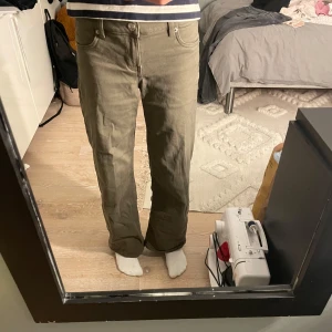 Olivgröna byxor från H&M Divided - Säljer ett par olivgröna byxor från H&M Divided. Byxorna har en rak passform och är tillverkade i bomull med en liten del elastan för extra komfort. Jeansen är för små för mig och därför säljer jag dem. 