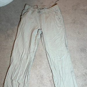 Beige byxor från 157 - Säljer ett par bekväma beige byxor från 157. Byxorna har elastisk midja och praktiska fickor. Perfekta för en avslappnad stil. Linnébyxorna är lite skrynkliga men kan skickas strunta om det önskas!