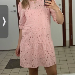 Rosa klänning med broderade detaljer - Söt rosa klänning med broderade detaljer och trekvartsärmar. .