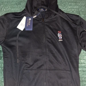 Svart hoodie från Ralph Lauren - Polo Raulph Lauren hoodie i storlek M. Aldrig använt. Taggar följer med. Pris kan diskuteras via snabbaffär.