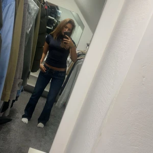 Svart polotopp i ull - Snygg svart polotopp i mjuk ull med korta ärmar. Perfekt för en stilren look och passar bra till jeans eller kjol. Toppen har en tight passform som framhäver figuren. (Finns fler bilder)