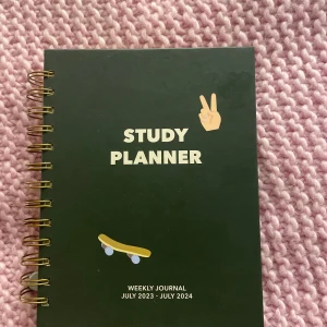 Grön Study Planner - Säljer en grön Study Planner med spiralbindning för perioden juli 2023 till juli 2024. Planeraren har flikar för varje månad och inkluderar sektioner för veckovisa aktiviteter, favoriter och anteckningar. Perfekt för att organisera studier och dagliga aktiviteter. Går även att använda för senare år. väldigt fint skick.