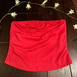 Röd tubtopp - Snygg röd tubtopp perfekt för sommardagar. Enkel design utan axelband och i ett mjukt material som sitter bekvämt. Passar utmärkt till både jeans och kjol.