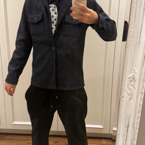 Mörkblå overshirt från John Henric - Snygg mörkblå overshirt från John Henric med knappar och två bröstfickor. Perfekt för lager-på-lager-stil och passar bra till både vardag och mer uppklädda tillfällen.
