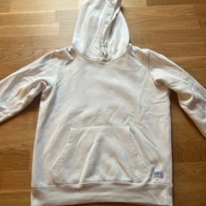 Vit hoodie från Jack & Jones - Säljer en stilren vit hoodie från Jack & Jones. Den har en klassisk design med känguruficka. Perfekt för en avslappnad look.