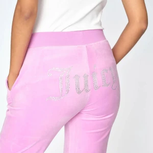 Rosa byxor från Juicy Couture - Snygga rosa byxor från Juicy Couture med glittrande stenar som bildar texten 'Juicy' på baksidan. Finns en effekt på byxorna, fråga om bild. Köpta på nk 