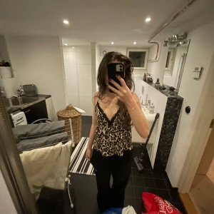 Leopardmönstrad linne från Gina Tricot - Säljer ett snyggt leopardmönstrat linne från Gina Tricot i storlek XS. Linnet har smala axelband och v-ringning med spetsdetaljer. Aldrig använd med prislapp kvar. Nypris 139