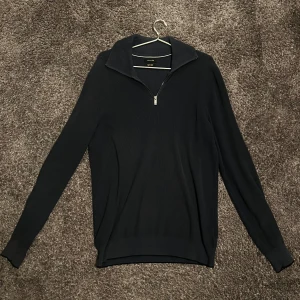 Mörkblå tröja med dragkedja från Massimo dutti. - Snygg mörkblå tröja från Massimo dutti med dragkedja vid halsen. Perfekt för kyligare dagar med sin långärmade design och ribbade struktur. En stilren och mångsidig tröja för garderoben.