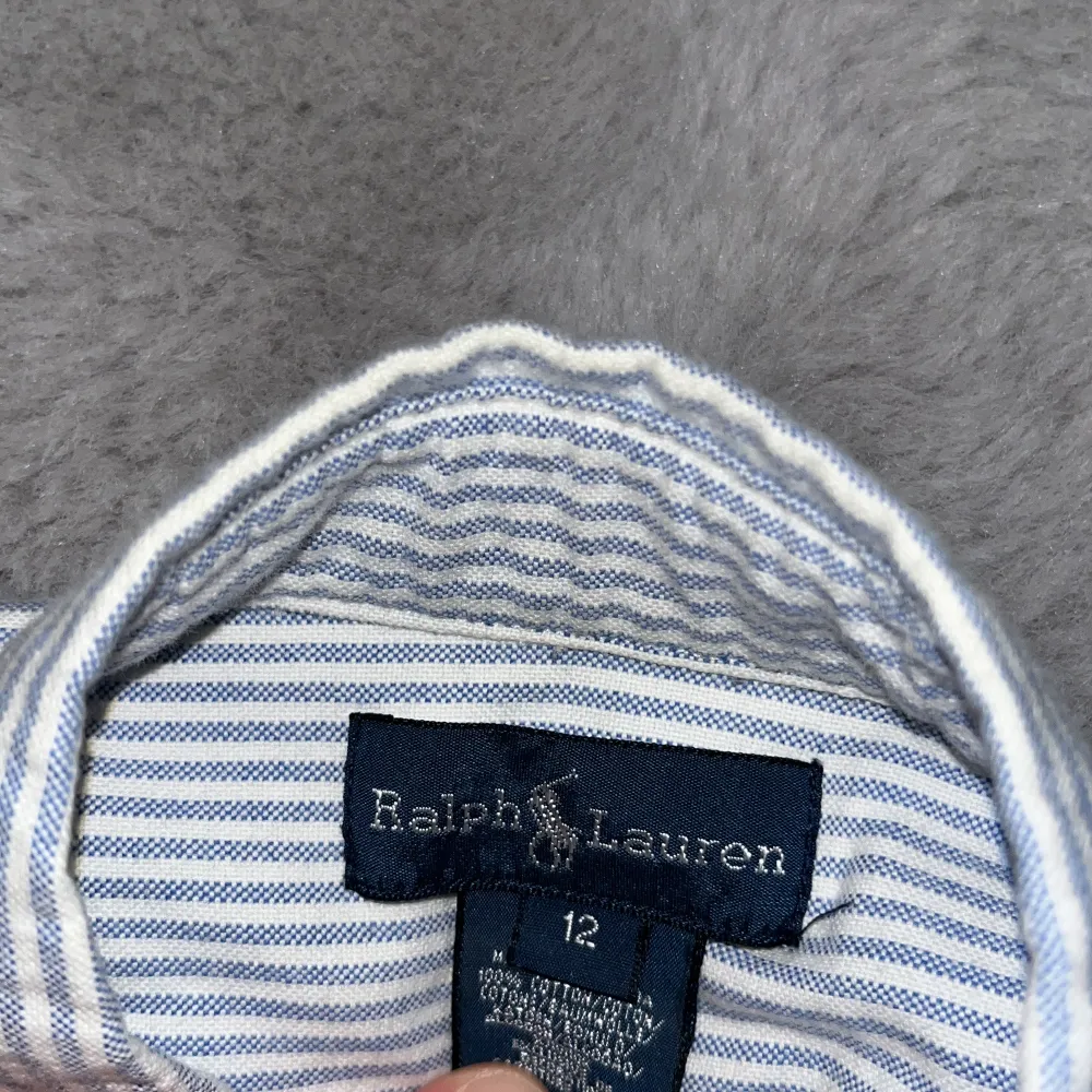 Säljer en asfet skjorta från Ralph lauren som är vitblå randig och är i väldigt bra skick 8/10 knappt använd och är i storleken 12 men passar folk mellan 154 till 164 själv är jag 164 och den är nästan lite liten hör av er vid minsta fråga/fundering //Calle. Paidat.