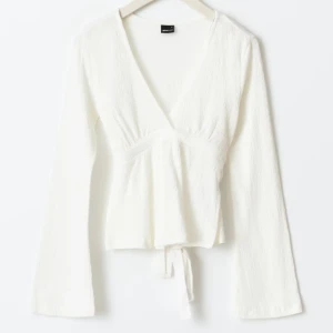 Vit omlottopp med knytband - V ringad tröja från Gina som man knyter i ryggen . Knappt använd och kommer inte till användning 💕