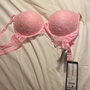 Rosa spets-bh med super push - Säljer en söt rosa bh med spetsdetaljer och super push-effekt. Den har justerbara axelband och en elegant design som ger extra lyft. Perfekt för att känna sig extra fin. Säljer pågrund av att jag köpte fem storlek. Helt oanvänd!