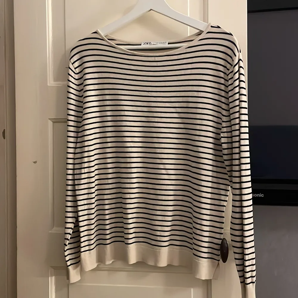 Säljer en stilren randig tröja från Zara i beige och svart. Tröjan har en avslappnad passform med långa ärmar och rund halsringning. Perfekt för en casual look.. Neuletakit & Villapaidat.