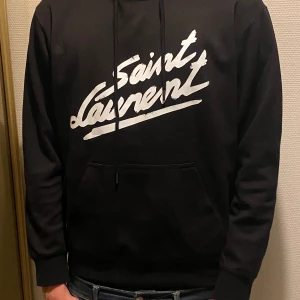 Svart hoodie från Saint Laurent - Snygg svart hoodie från Saint Laurent med vit logga på bröstet. Helt ny.
