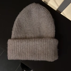 Vit grå beige stickad mössa från Pieces - Säljer en vit grå beige stickad mössa från Pieces. Passar de flesta men för liten för mig.💓