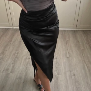 Zara svart satinkjol med slits - Säljer denna fina svarta satinkjolen från zara. Super elegant! Passar till både vardags & fest!  Super bra skick!😍
