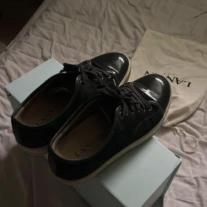 Svarta sneakers från Lanvin - Säljer ett par snygga svarta sneakers från Lanvin. Skorna är i bra skick, det ända är att dom är lite smutsiga. Skorna kommer med originalförpackning och dustbag. Priset går att diskutera. 