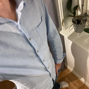 Ljusblå linneksjorta  - Säljer nu min riktigt snygga linneskjorta i ljusblå, skjortan är i storlek medium och från dressman, och den är i väldigt fint skick 