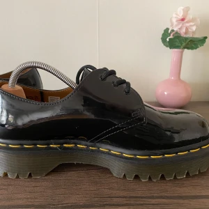 Svarta lackskor från Dr. Martens - Säljer ett par snygga svarta lackskor från Dr. Martens. De har en glansig finish och klassisk snörning. Inte mycket använda men finns ett litet märke på vänster fram, men inget man läger direkt märke till. 