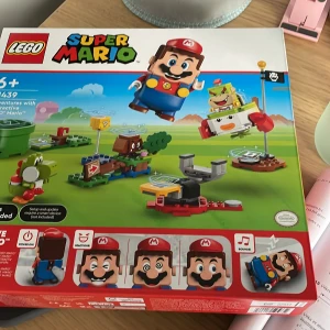 LEGO Super Mario Set - Det här är ett LEGO Super Mario set . Setet innehåller en interaktiv Mario-figur och flera byggbara delar som inkluderar karaktärer som Yoshi och Bowser Jr. Det är designat för barn från 6 år och uppåt . Oanvänd, oöppnad