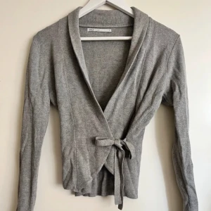 Kofta med rosett - Säljer denna kofta med rosett som man kan byta eftersom jag ej använder den.