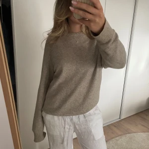 Beige stickad tröja - Grå/ beige stickad tröja i ull blend med detaljer vid axlarna. Bra skick