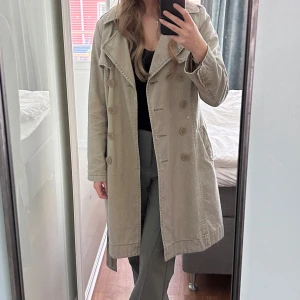 Trenchcoat  - Beige trenchcoat i jeans material. Bra skick! Passar storlek xs-m