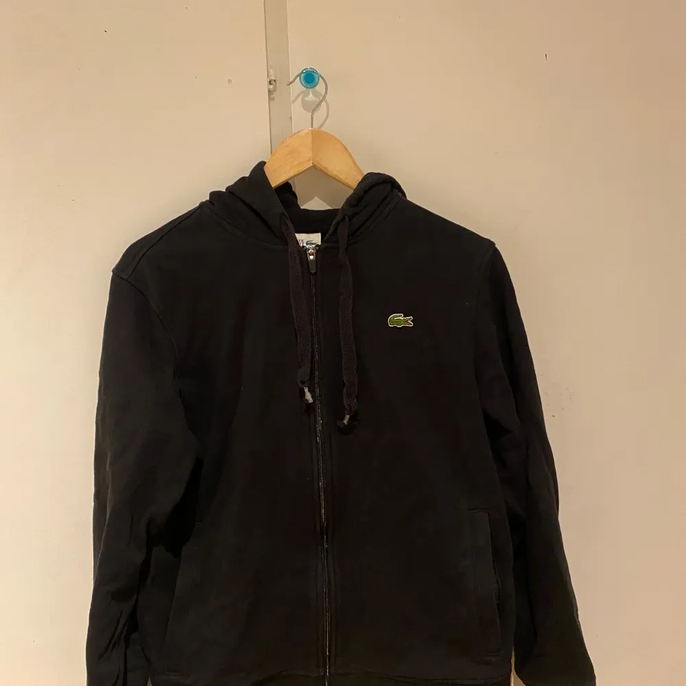 Lacoste hoodie i storlek m Har använts ganska mycket så säljer den ganska billigt dock inget som är sönder på tröjan  Möts bara upp vid sälj!. Hoodies.