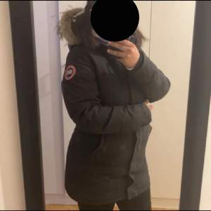 En äkta svart canada goose med en dragkedja sönder, går att fixa hos skräddare. 