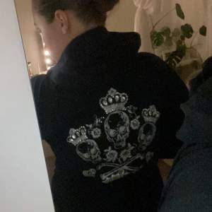 Säljer en svart hoodie från Victoria's Secret i bra skick. Den har en cool design med dödskallar och kronor i silver på ryggen. Perfekt för höst och vinter med dragkedja framtill och långa ärmar. Superbekväm! ( det finns några diamanter som har försvunnit där bak )