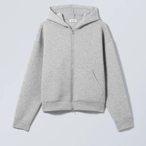 Grå hoodie med dragkedja från Weekday - Säljer en stilren grå hoodie från Weekday i mycket bra skick. Den har en praktisk dragkedja framtill och en skön huva. Perfekt för både höst och vår, och funkar lika bra till vardags som till chillkvällar. Storleken är normal och materialet är mjukt och bekvämt.
