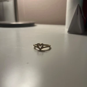 Guldring med hjärtdetalj från Pandora  - Säljer en superfin guldring från Pandora med en söt hjärtdetalj. Perfekt för att ge lite extra kärlek till din outfit. Ringen är i mycket bra skick och kommer i originalförpackning. Passar perfekt som present eller för att skämma bort dig själv! 💖