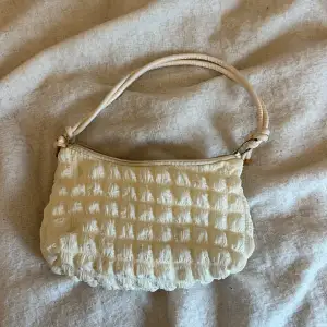 Säljer en superfin beige/vit axelväska med quiltat mönster. Den har en praktisk dragkedja och en bekväm axelrem. Perfekt för att ge din outfit en mysig touch! 👜