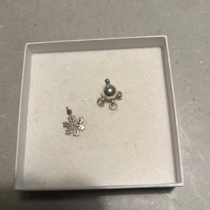 Silverörhängen med snöflinga och kula - Säljer ett par unika silverörhängen. Ena örhänget har en vacker snöflingeform, perfekt för vintern. Det andra örhänget är en stilren kula med små detaljer. Passar både till vardag och fest. Kommer i en fin presentask.
