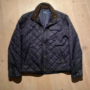 Ralph Lauren - Jacka - Tja! Säljer denna schyssta quiltade raffe jacka. Den är i bra skick förutom lite slitage på knapparna. Den har ett snyggt Manchester mönster på kragen! Vid minsta fråga eller fundering hör av er 🤝